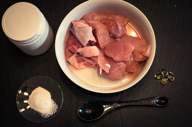 raw food consisting of chicken breast and vitamin supplements such as small capsules and a white powder