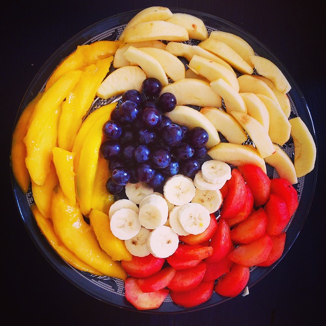 A bowl full of fruit including blueberries, banana, and strawberries.